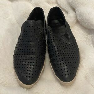 Black, perforated slip-on shoes with pointed toes.